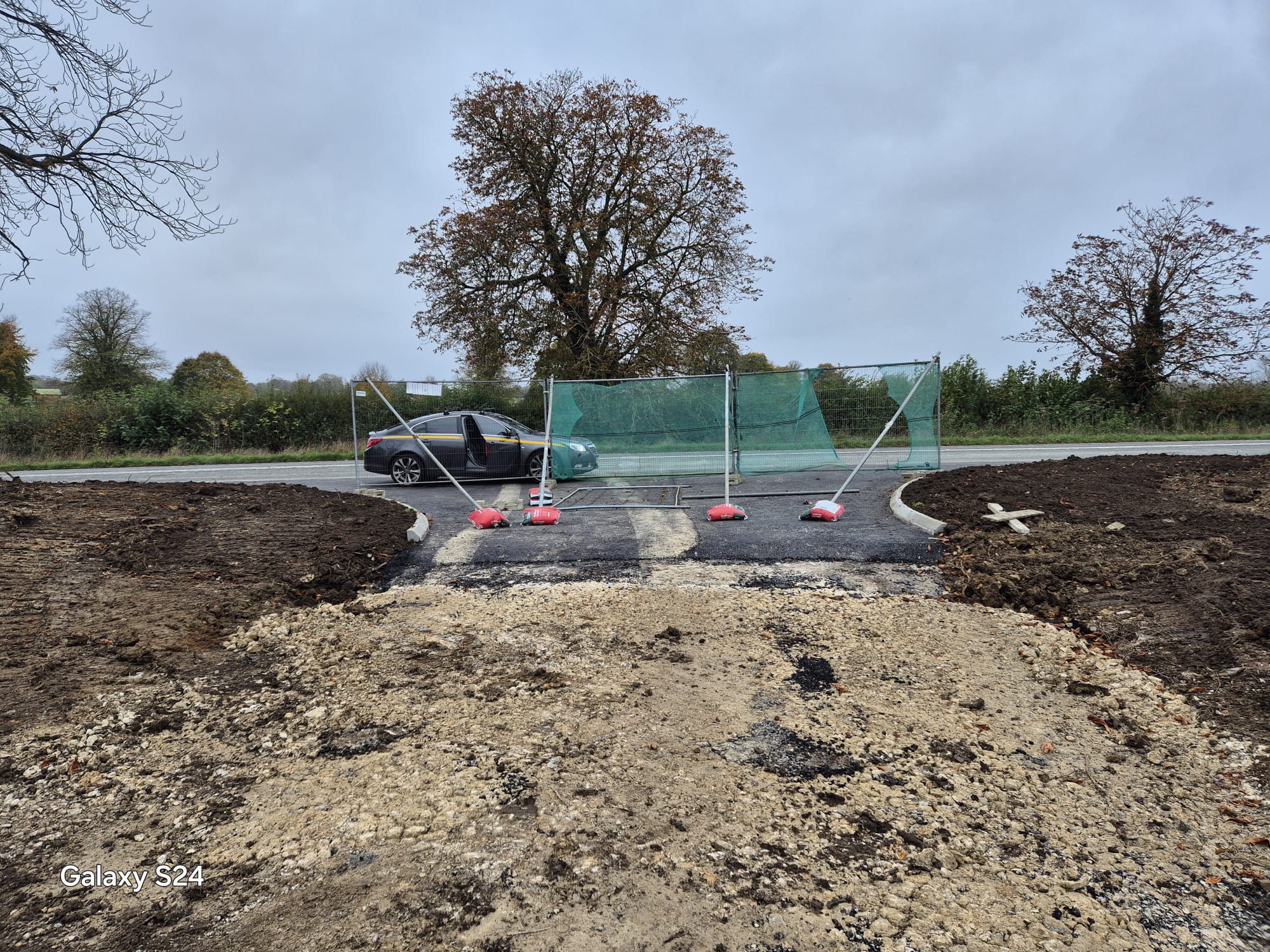 Heras fencing and ballast securing a new site access off a rural road once works were complete