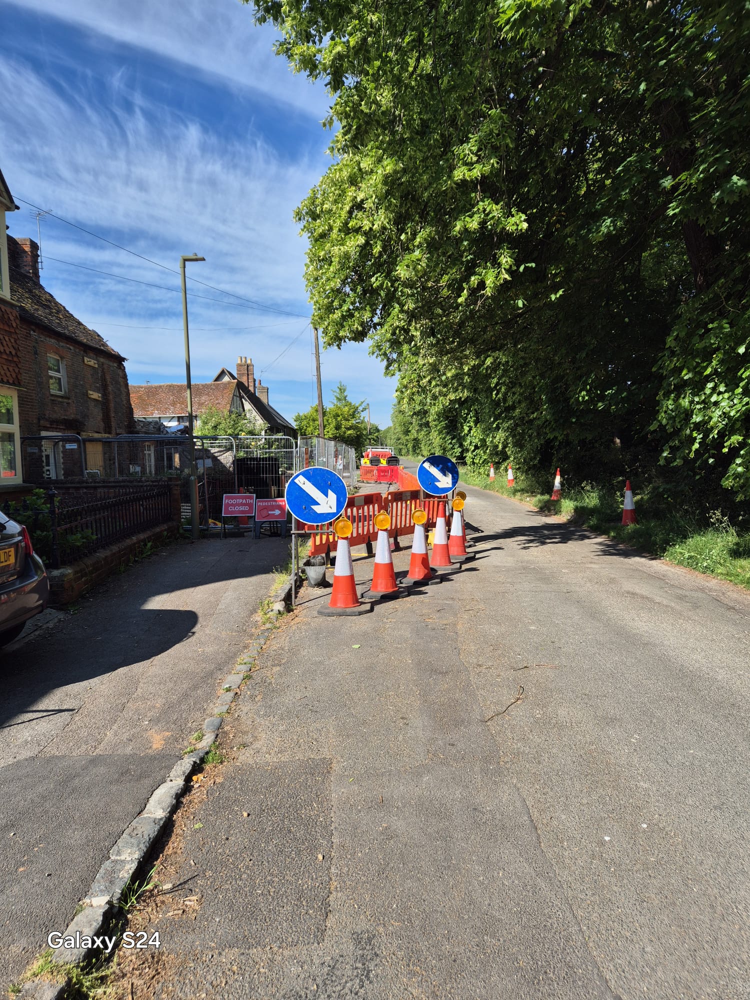Barriers and cones separating footway works from a residential street