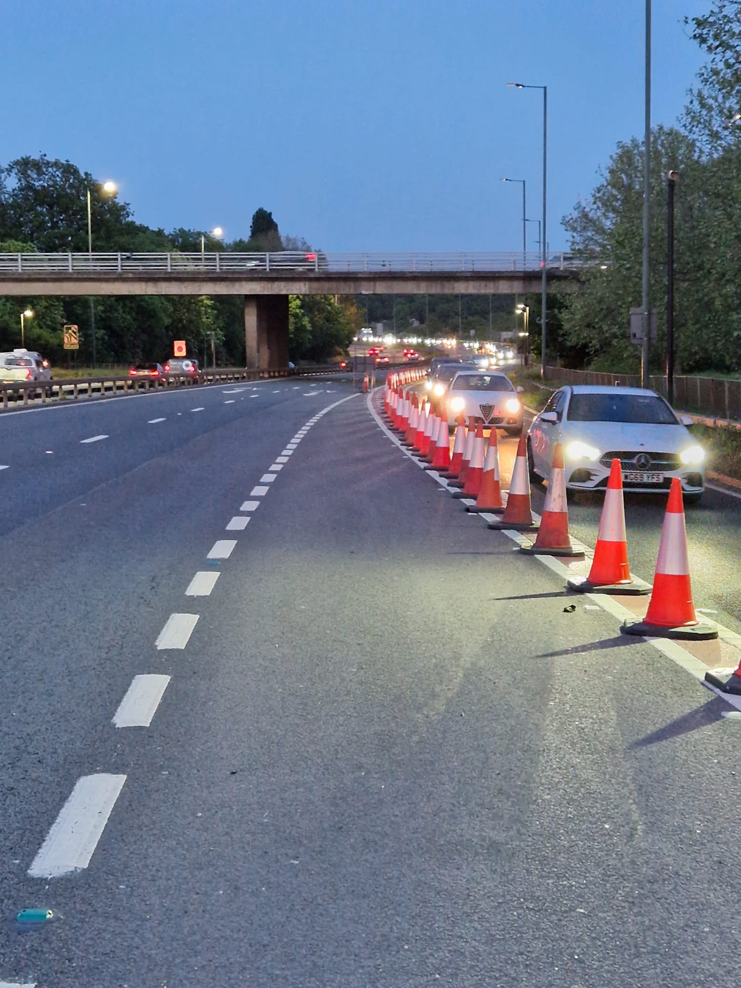 Curved cone line separating traffic from a work zone on a dual carriageway