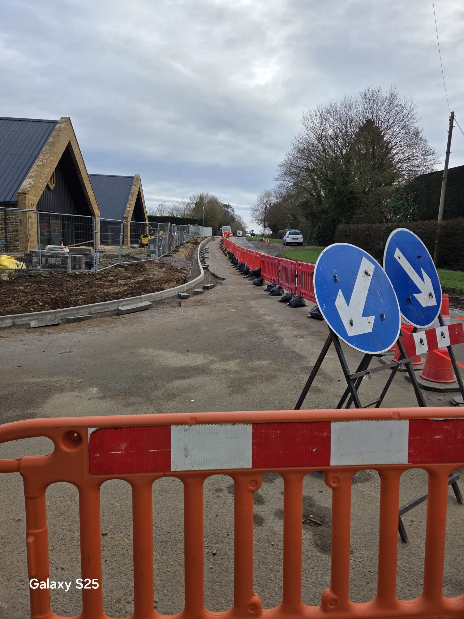 Barriers and keep-left arrow signs guiding traffic past low-speed road works