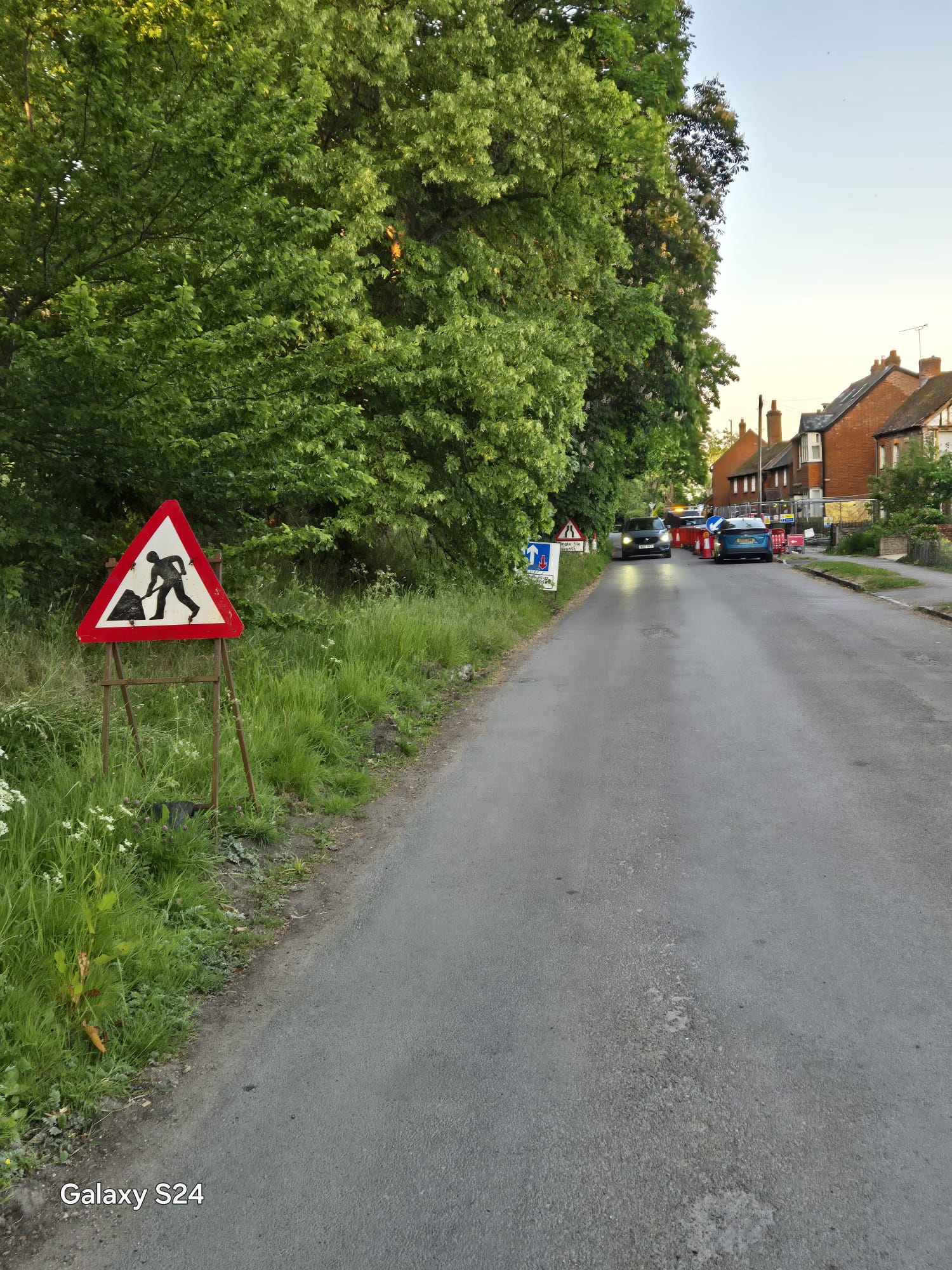 Road works ahead and single file traffic signage on the approach to a village works site