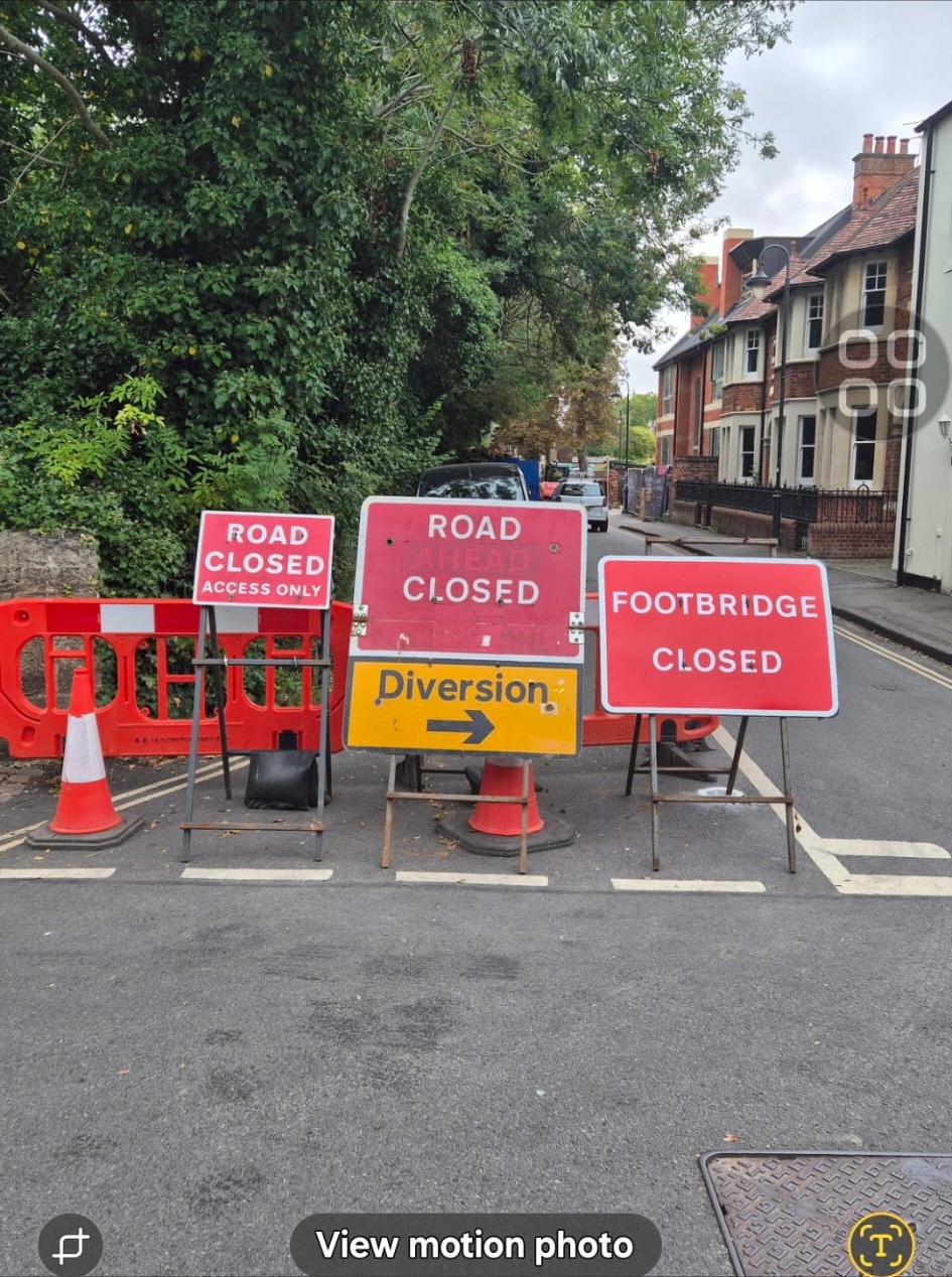 Road closed, diversion and footbridge closed signs closing a residential street