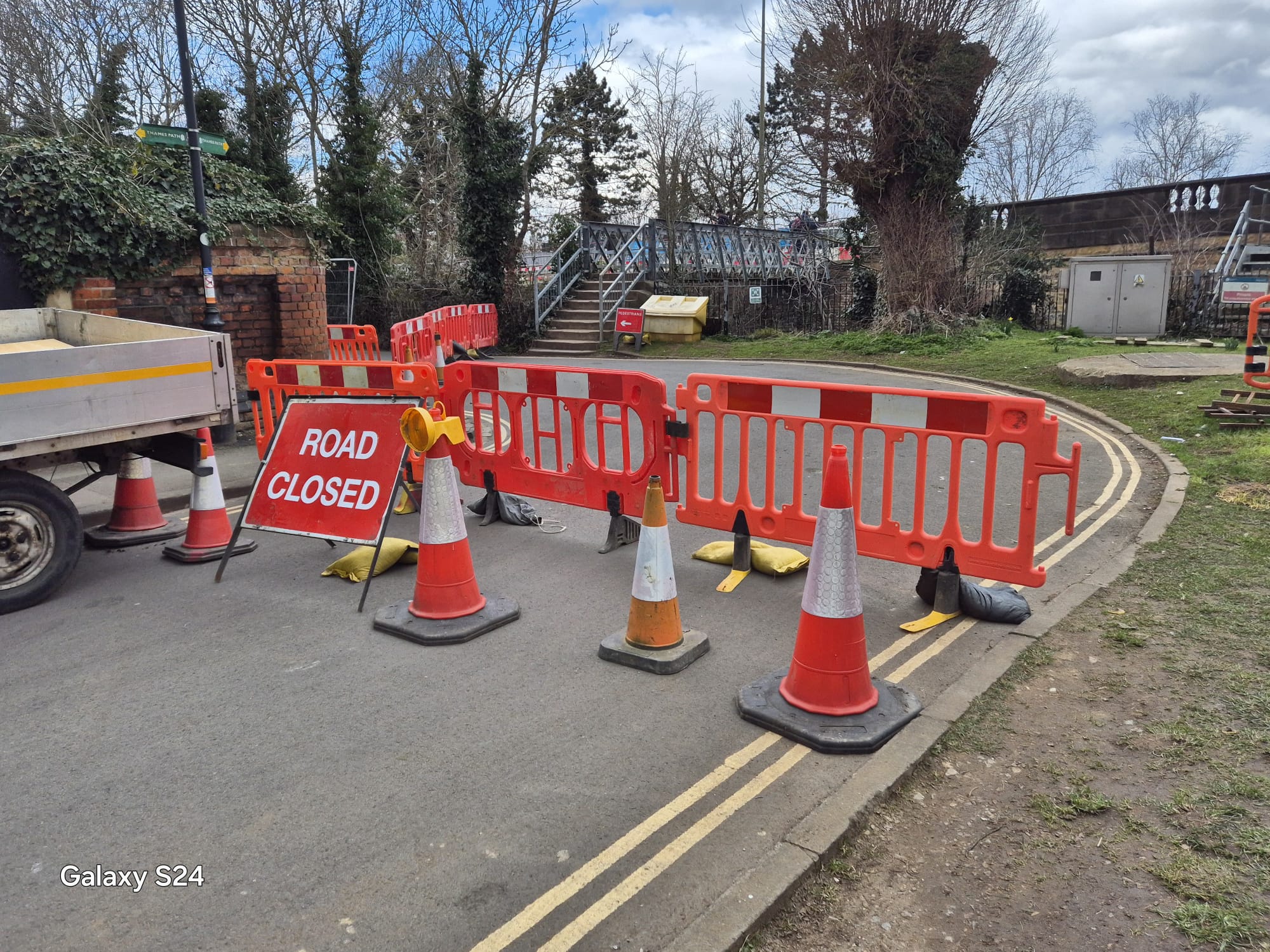 Road closed sign, cones and barriers closing a street around a bend
