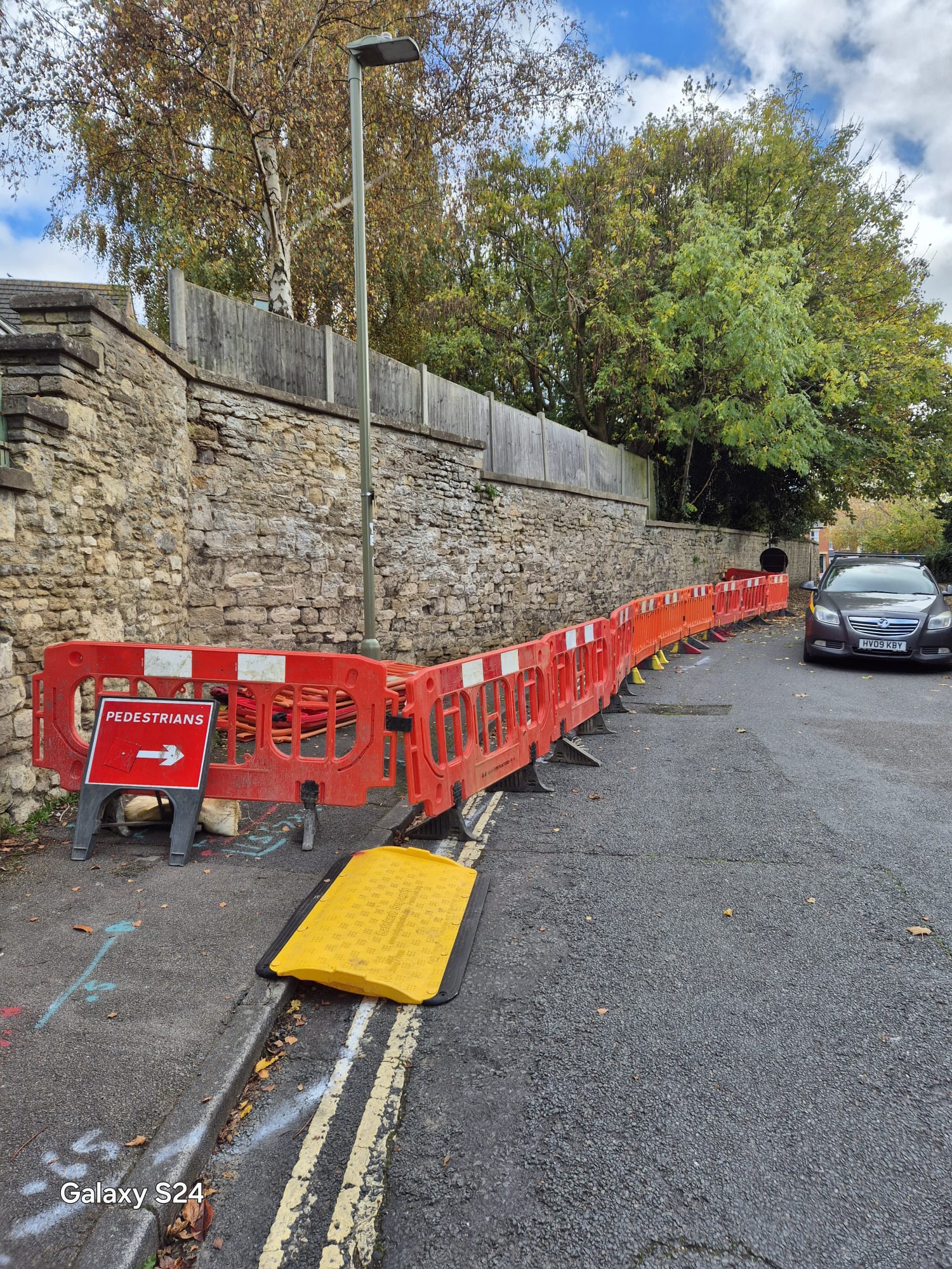 Footway closure with barriers and a cable ramp protecting pedestrians