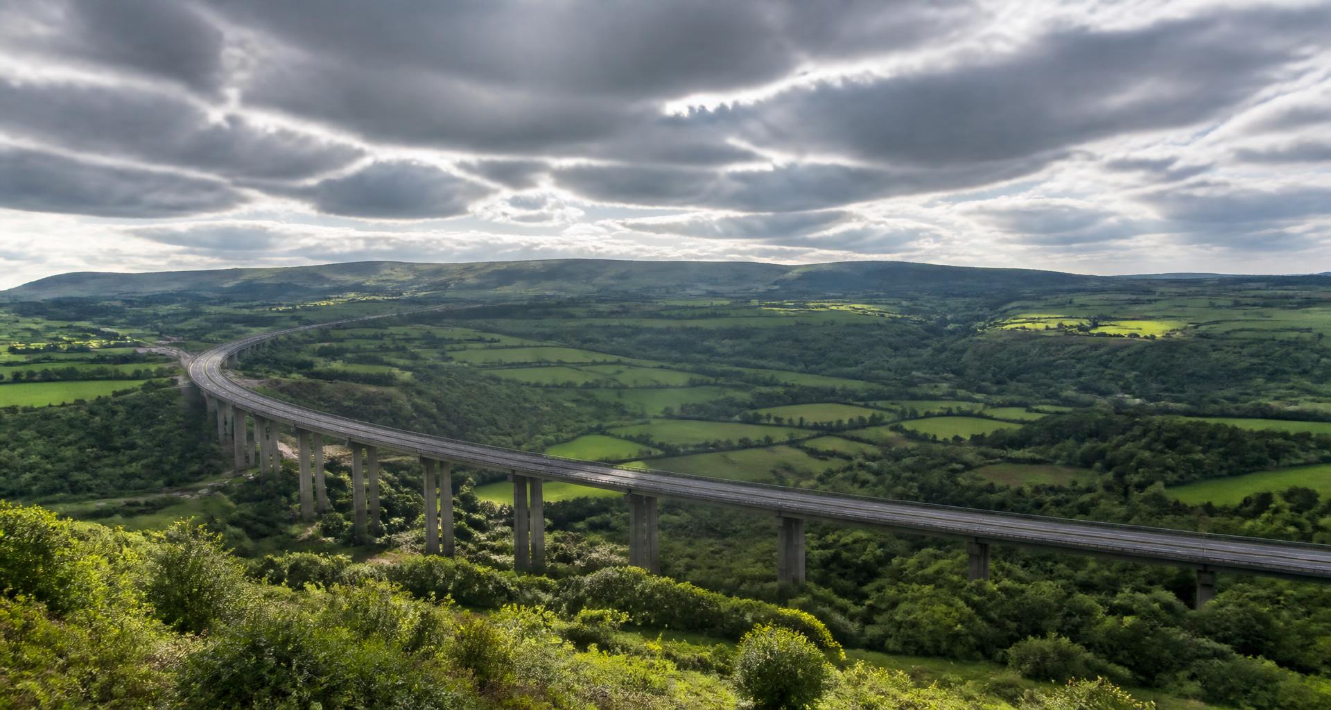 South West England motorway viaduct sweeping across a green valley of hedgerowed fields